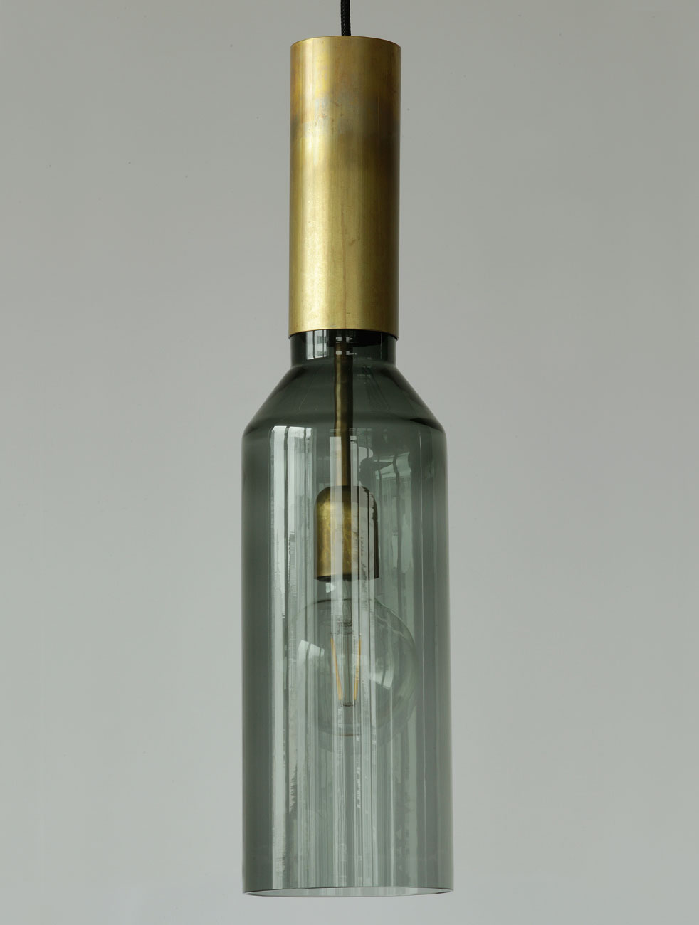 Design-Pendelleuchte aus Messing mit schmalem Glaskolben PHENO: Die Hängeleuchte in der Ausführung mit dunklem Rauchglas-Zylinder.