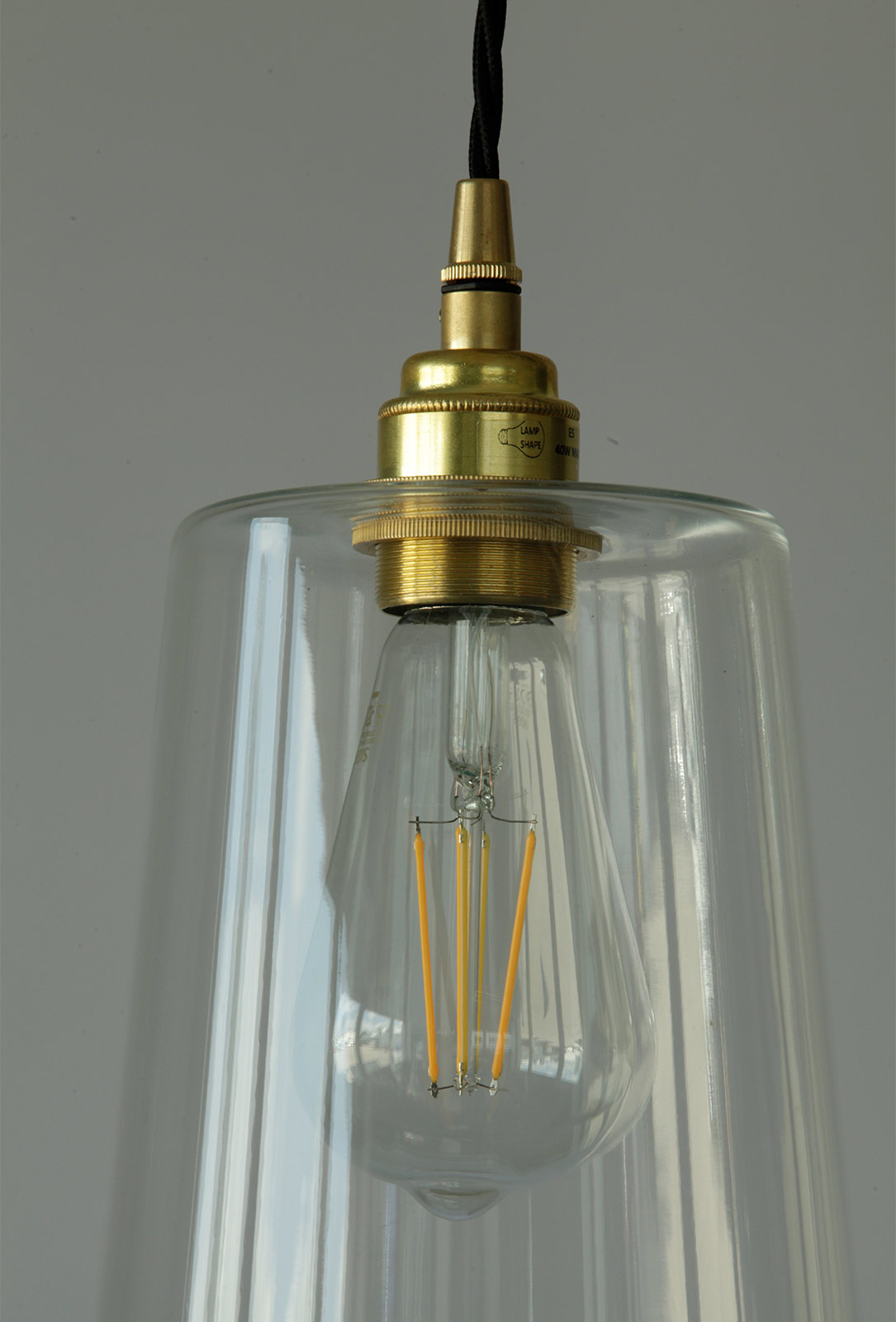 Schlanke Pendelleuchte mit 40 cm hohem Glas-Schirm: Glashalter und Fassung hier in Messing satiniert