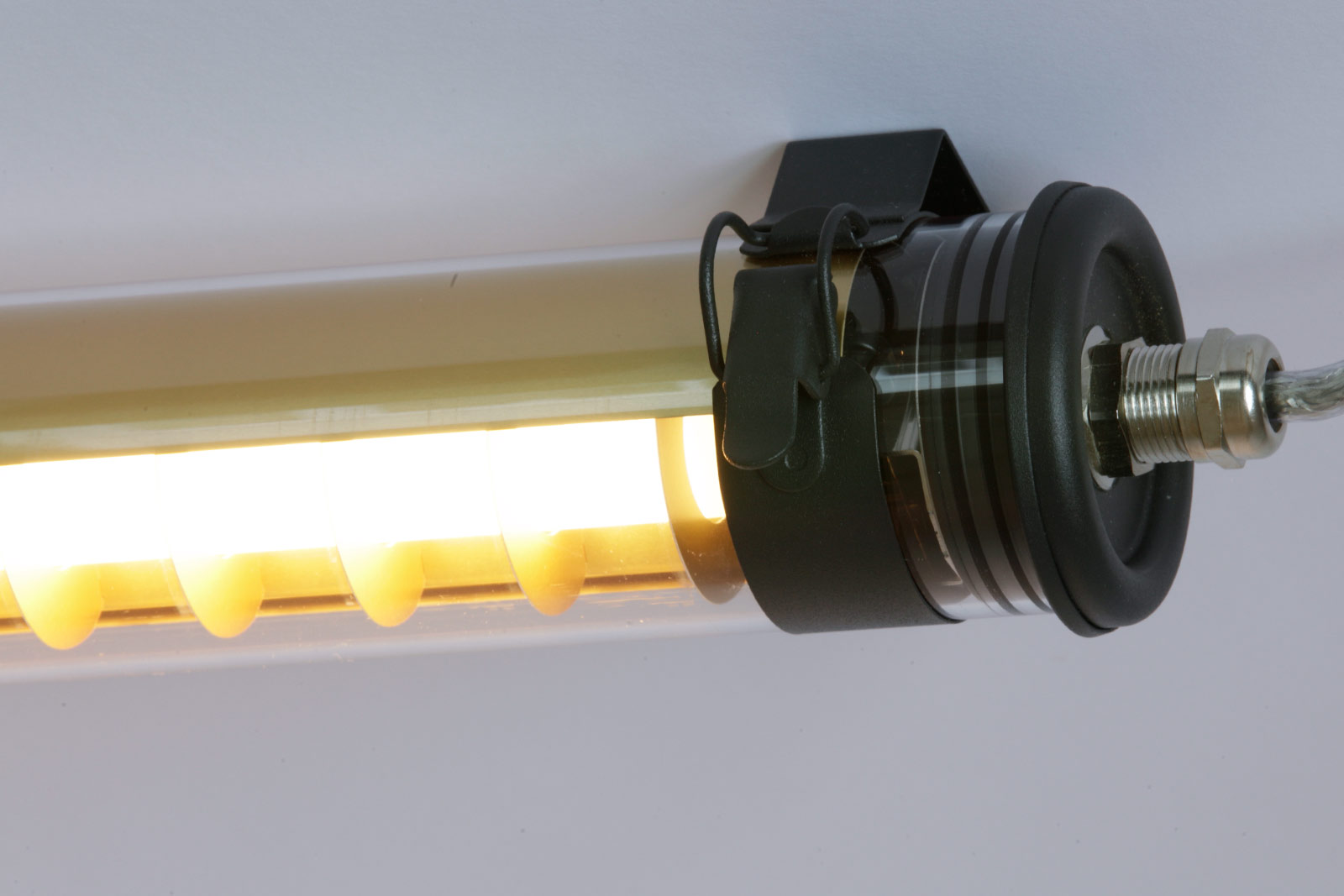 Schlanke LED-Röhrenleuchte PURCELL mit Lamellen (100/130 cm): Detail: Reflektor in Messing und mattschwarzen Armaturen („Coal“)