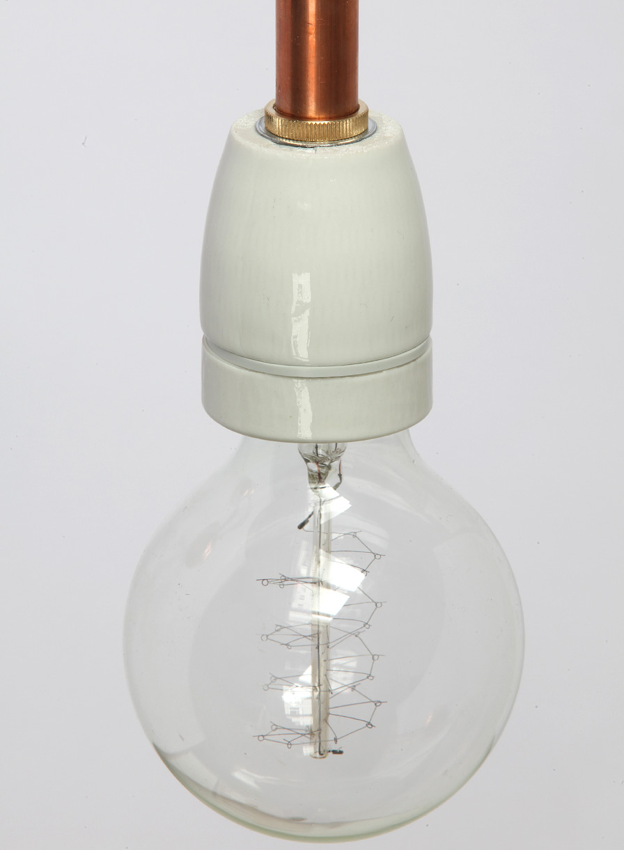 Minimalistische Wandleuchte mit Porzellanfassung: Detail der Porzellanfassung, bestückt mit „Globe“-Glühlampe