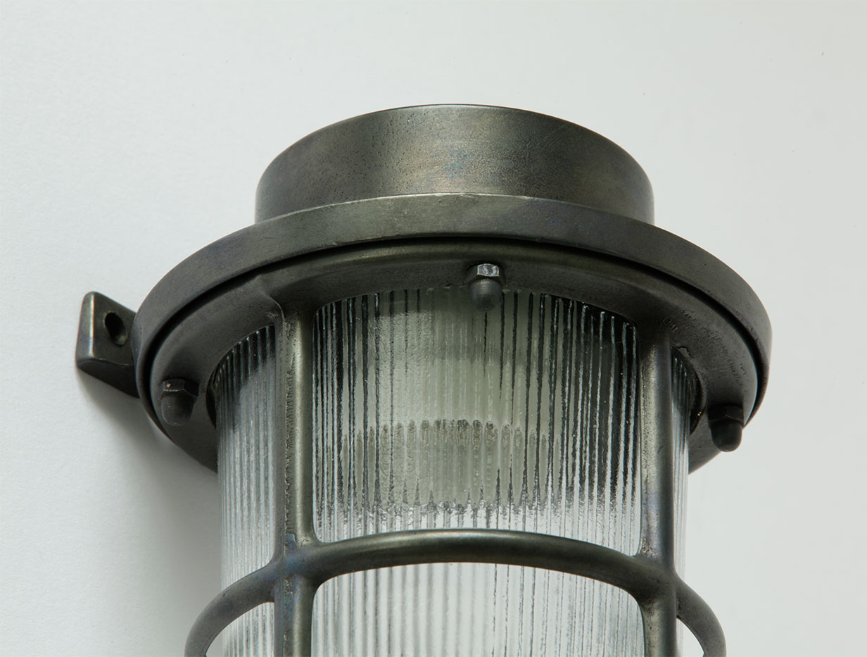 Nautische Wandlampe aus Messing und Rillen-Glaszylinder, Schutzgitter, IP64: Messing schwarz patiniert