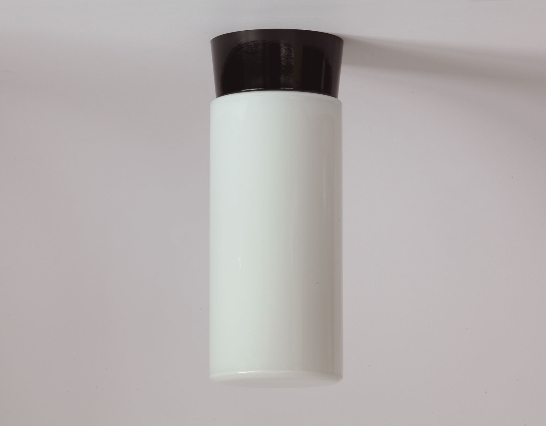 Zylinder-Deckenleuchte aus Opalglas mit Bakelit-Sockel: Puristische Formen und klassische Werkstoffe in schwarz und weiß